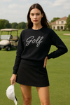 Women’s Golf Pearl Luxury Sweatshirt in black with functional tee holder on sleeve, soft performance fabric, and versatile comfort for golf and everyday activewear. Pullover design to make golf easy. 