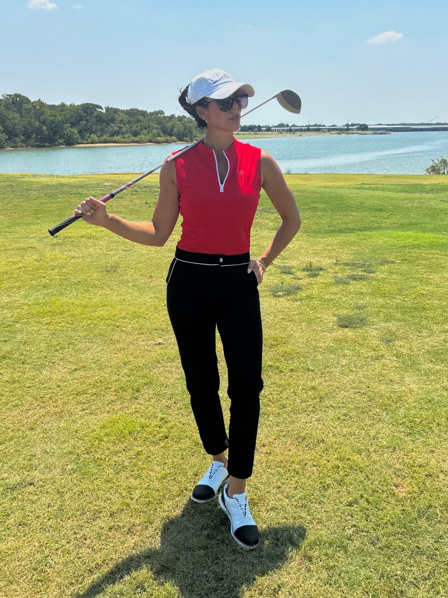 Mila Pants — premium women’s golf and activewear trousers in black with white piping, perfect for both golfing and office wear.Susanna Polo by Ashley Herrera — performance-driven red sleeveless activewear polo featuring a crisp white zipper and playful polka dot mock collar for an elevated look on the course or court.