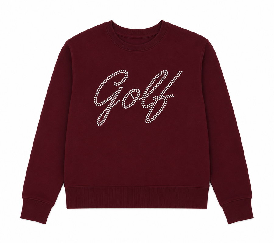 Front view of the Ashley Herrera Signature Golf Pearl Pullover in rich merlot featuring sparkling pearl "Golf" script, an ultra-soft premium fabric, a relaxed silhouette, and three integrated golf tee holders on the sleeve for elevated function and timeless style.

That sleeve detail is exactly the kind of thoughtful luxury feature buyers at private clubs appreciate, so it's worth calling out.