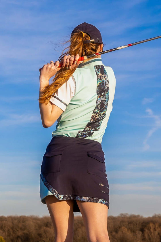 Model wearing Women’s Navy & Light Blue Snake Skort — 15-inch luxury skort with metallic snake-print accents, drawstring waist, pockets, and breathable, quick-dry performance fabric for golf, tennis, pickleball, or casual wear